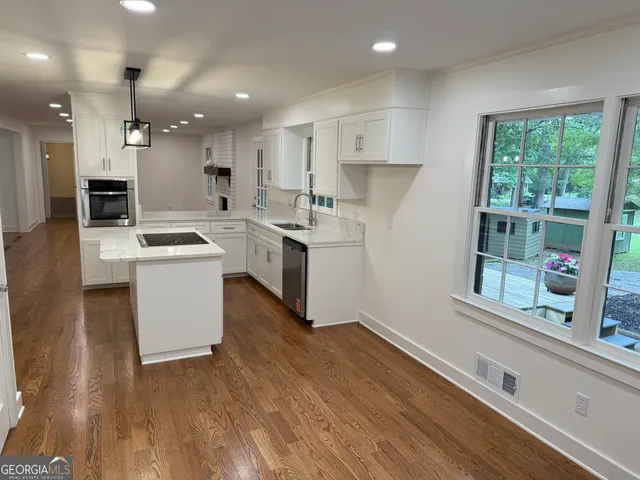 a kitchen that has a sink a stove and a refrigerator