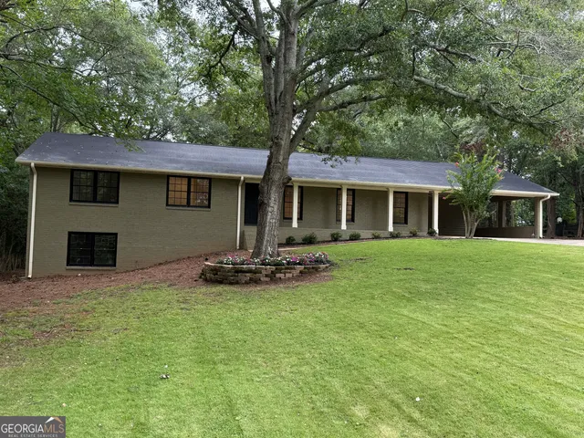 a front view of a house with a garden and yard