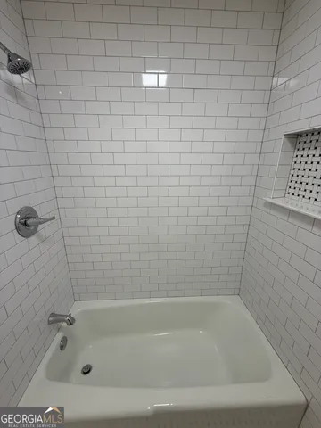 a view of an empty room with wooden floor and cabinet