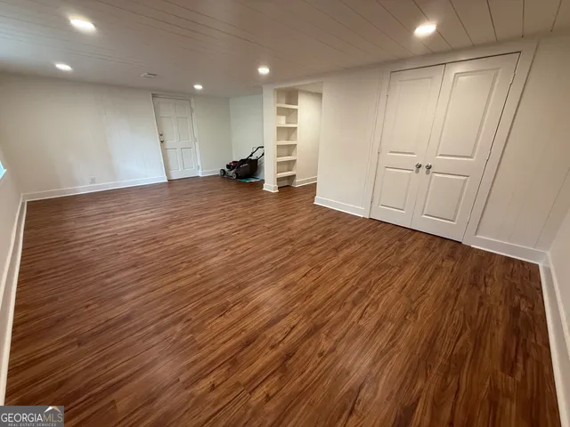 an empty room with wooden floor and entrance