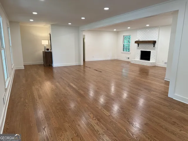 a view of empty room with wooden floor and fireplace