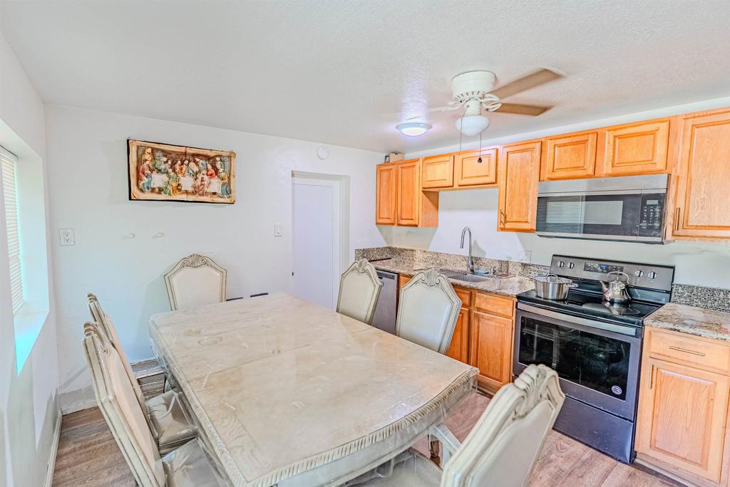 11977 Demi Lee Lane Lakeside, CA 92040 - Photo 17 of 22 a kitchen with granite countertop a stove a sink a dining table and chairs
