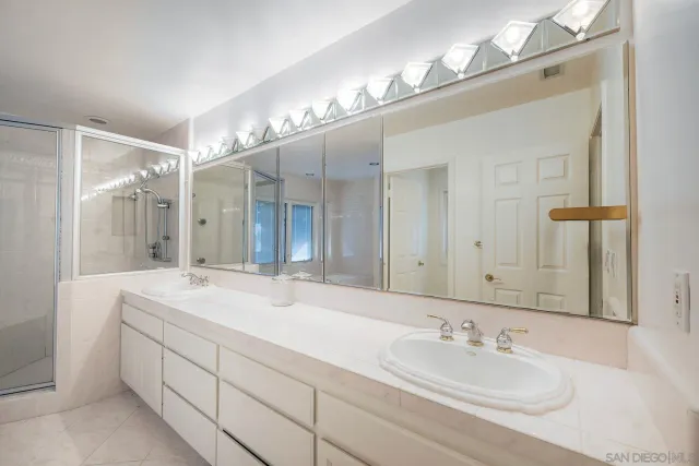 a bathroom with double vanity sinks and a mirror