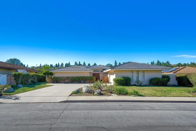 a view of a house with a yard and potted plants