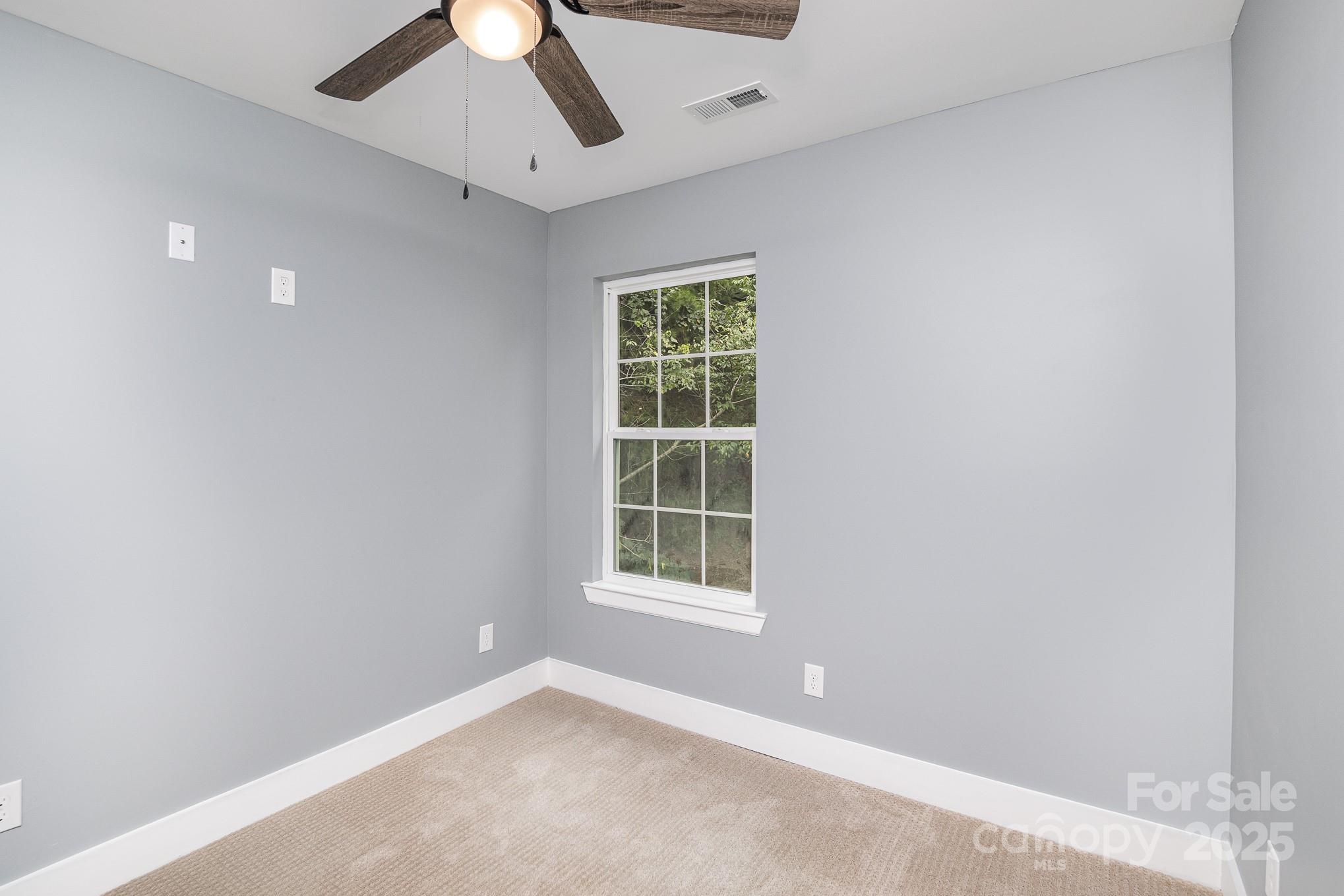 938 Valley Ridge Road Charlotte, NC 28214 - Photo 12 of 22 an empty room with a window and a fan