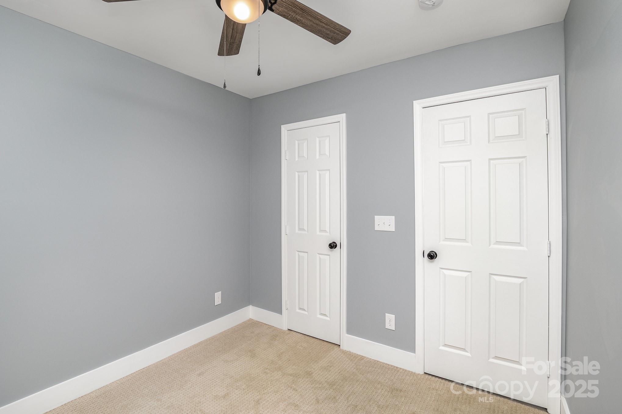 938 Valley Ridge Road Charlotte, NC 28214 - Photo 15 of 22 an empty room with chandelier fan and windows