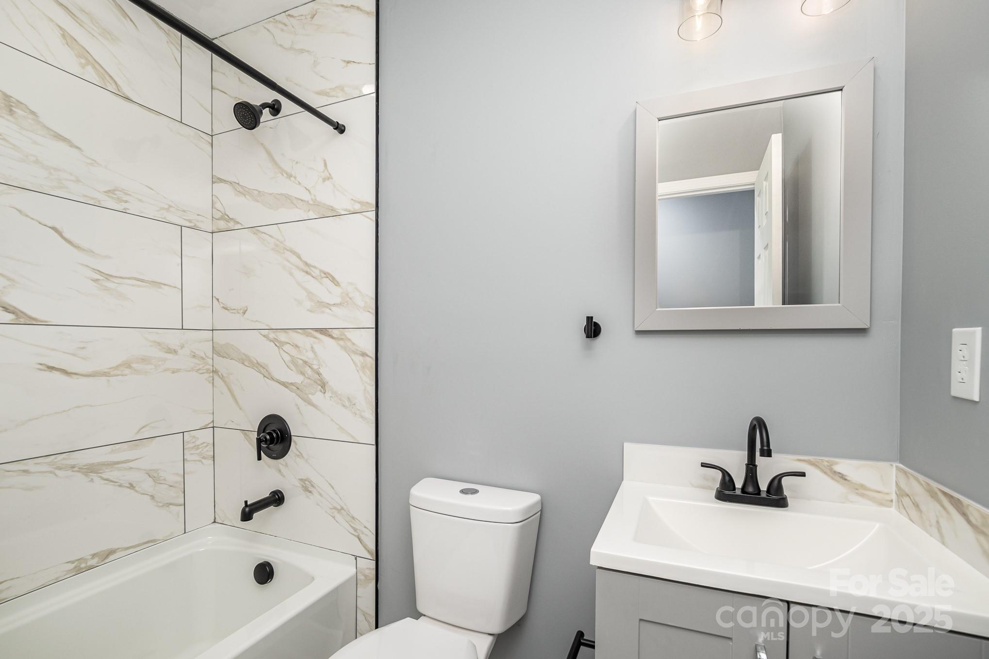 938 Valley Ridge Road Charlotte, NC 28214 - Photo 18 of 22 a bathroom with a sink a toilet and shower