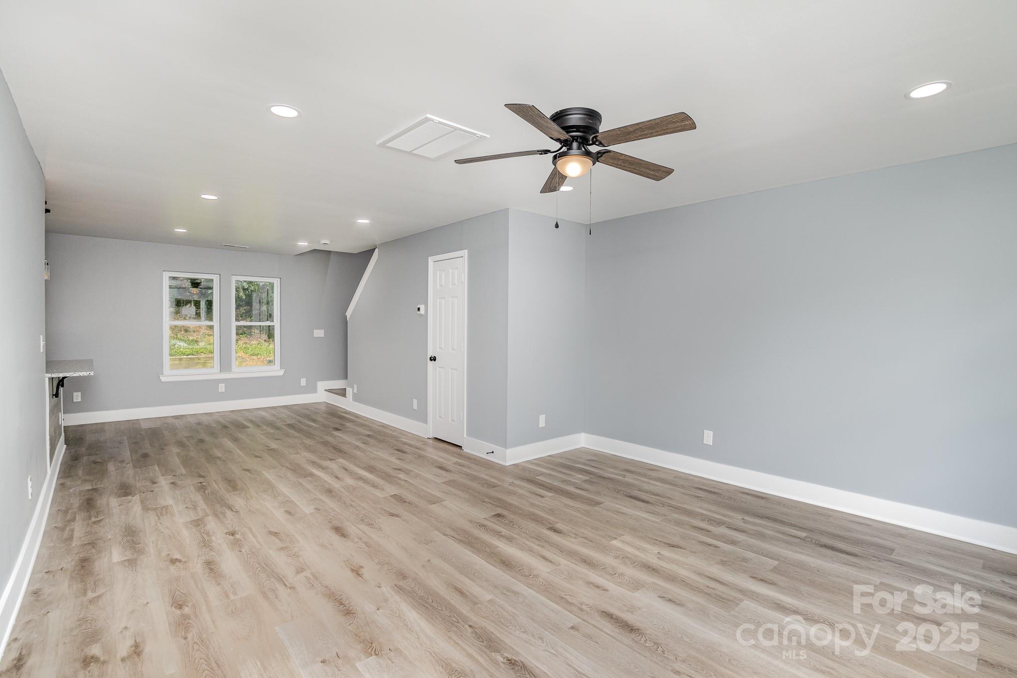 938 Valley Ridge Road Charlotte, NC 28214 - Photo 3 of 22 a view of empty room with wooden floor and fan