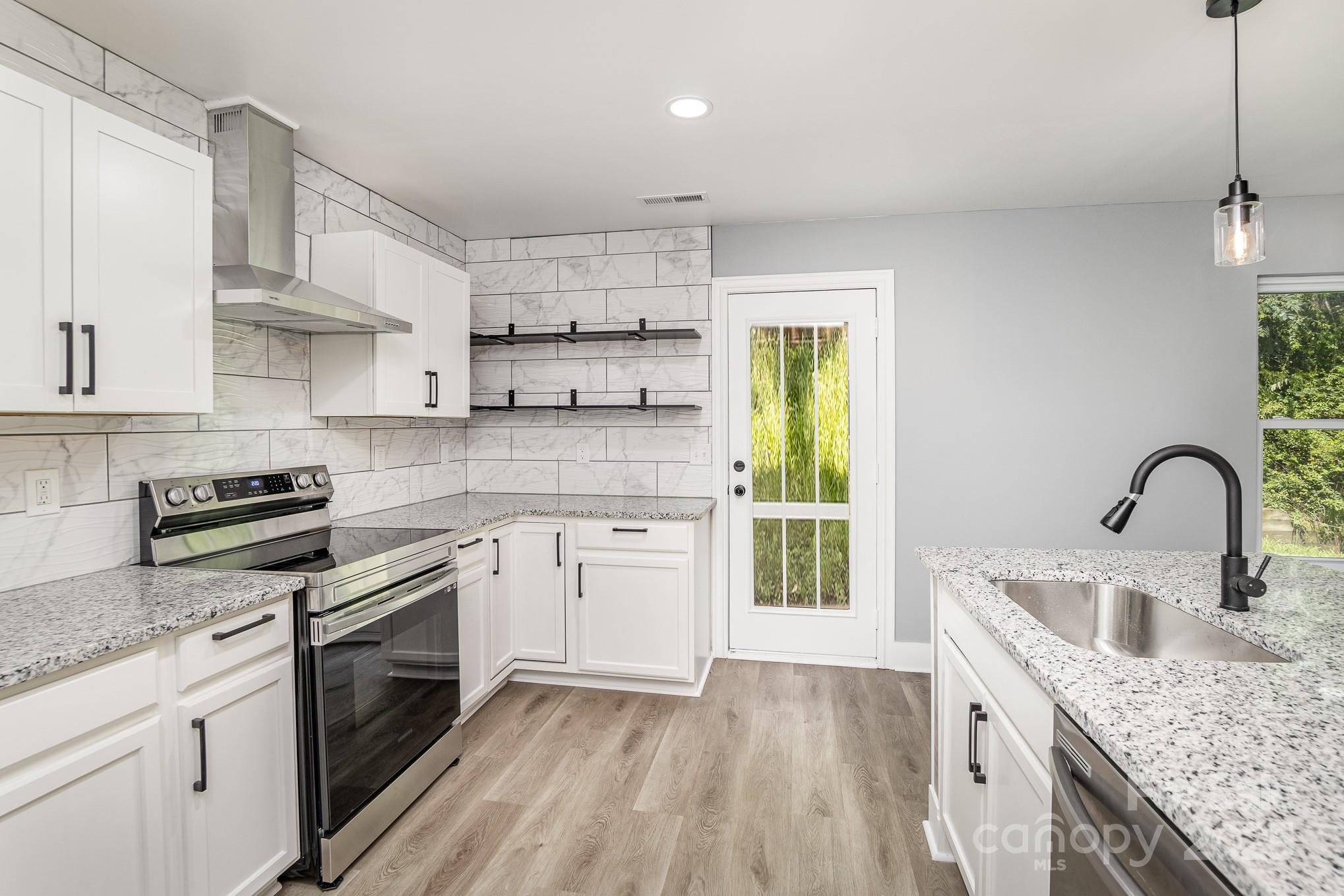 938 Valley Ridge Road Charlotte, NC 28214 - Photo 6 of 22 a kitchen with kitchen island granite countertop a sink stainless steel appliances and cabinets