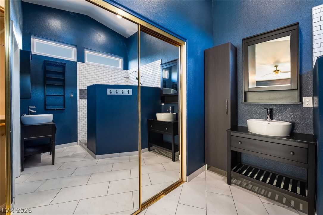 261 Timber Hollow Street Henderson, NV 89012 - Photo 36 of 51 Bold blue walls complement the sleek tile flooring and modern vanity in this functional bathroom.