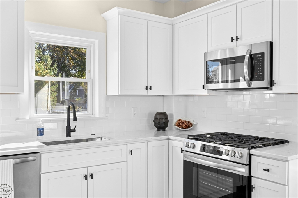 15 Arthur Street, Unit 15 Maynard, MA 01754 - Photo 10 of 21 a kitchen with stainless steel appliances a stove a white cabinets and a window
