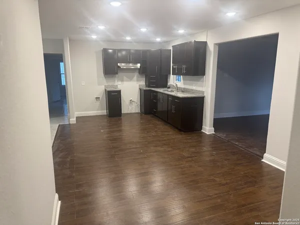 a large room with kitchen view and a sink