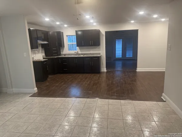 a kitchen with kitchen island granite countertop a sink and a stove top oven