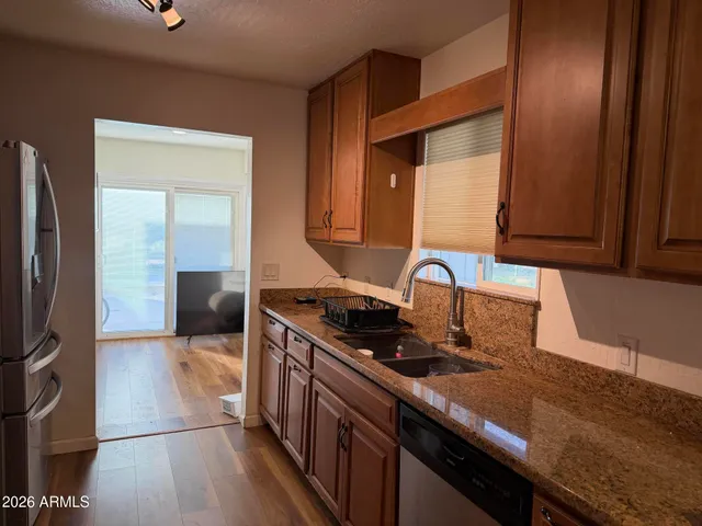 a kitchen with stainless steel appliances granite countertop a stove a sink and a refrigerator