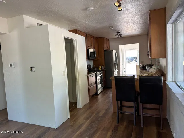 a kitchen with sink refrigerator dining table and chairs