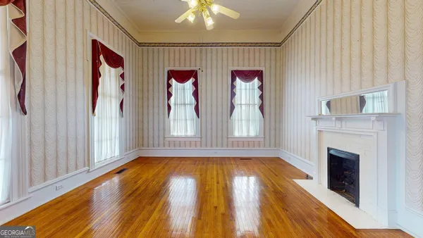 a view of a big room with wooden floor and windows