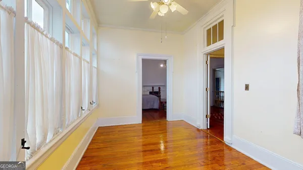 a view of a hallway with wooden floor and stairs