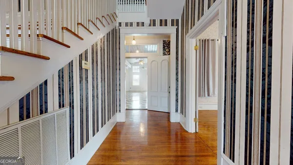 an empty room with wooden floor cabinet and front door