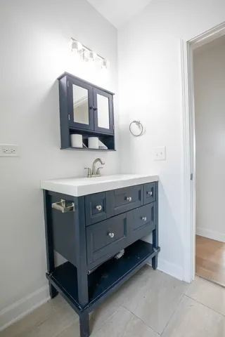 a bathroom with a sink vanity and mirror