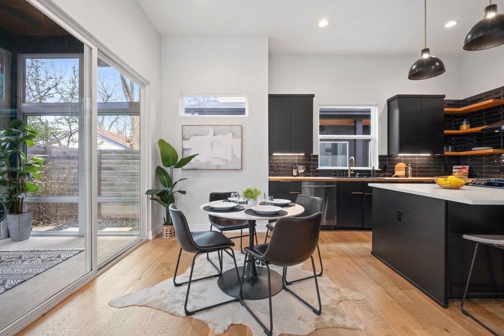 928 East 53rd 1/2 Street, Unit 1 Austin, TX 78751 - Photo 14 of 40 Kitchen featuring dark cabinetry, light countertops, a kitchen bar, hanging light fixtures, and decorative backsplash