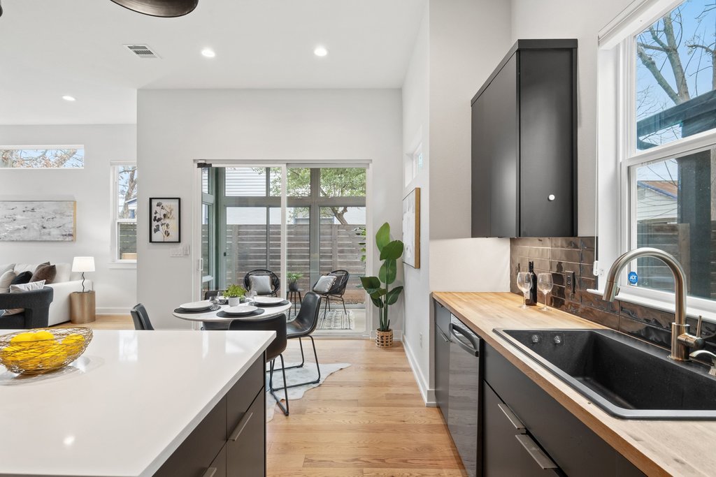 928 East 53rd 1/2 Street, Unit 1 Austin, TX 78751 - Photo 40 of 40 Kitchen featuring dark cabinets, light wood-style floors, open floor plan, tasteful backsplash, and dishwasher