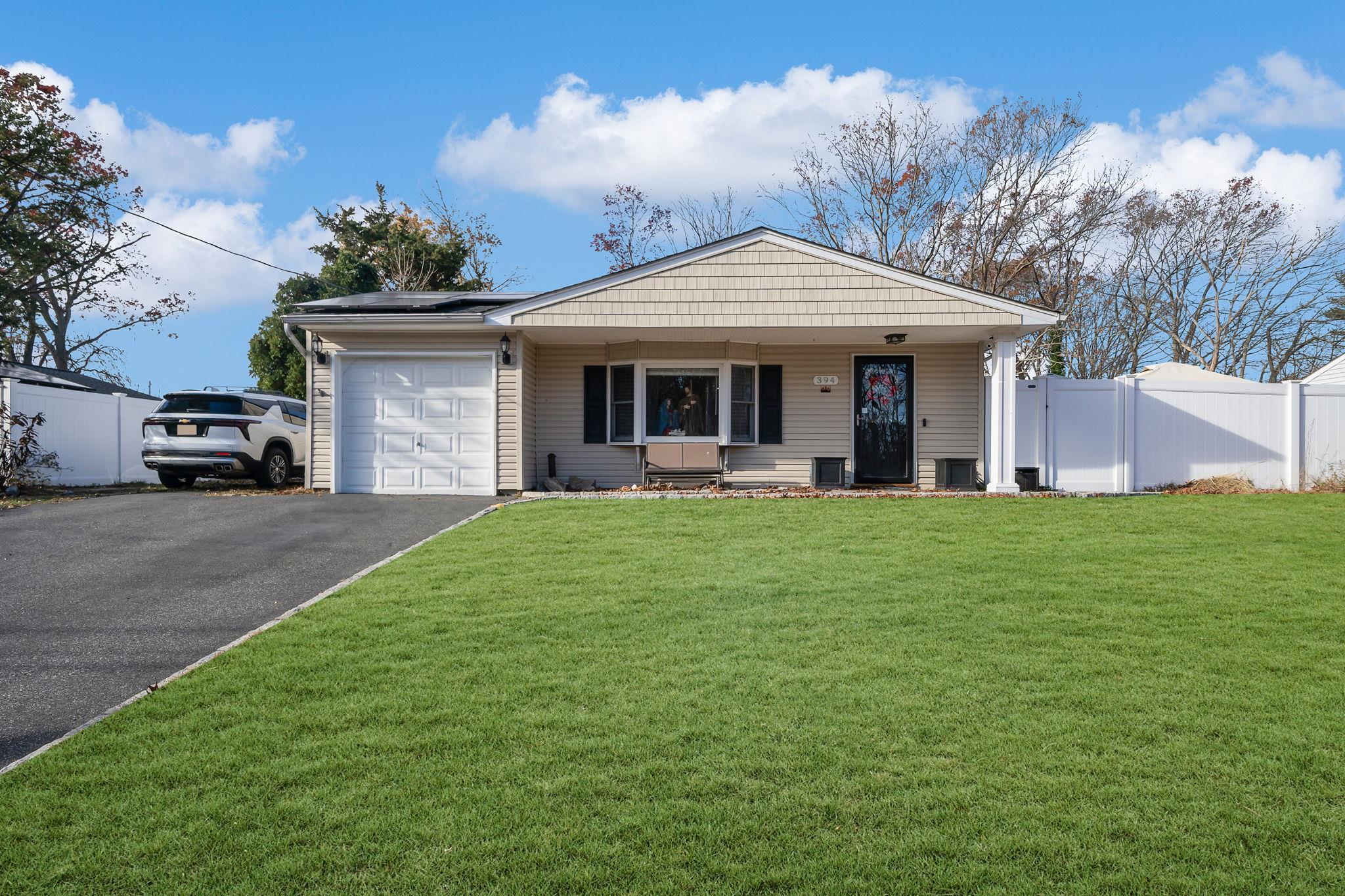 394 Boyle Road Selden, NY 11784 - Photo 1 of 1 View of front of house with a front yard and a garage