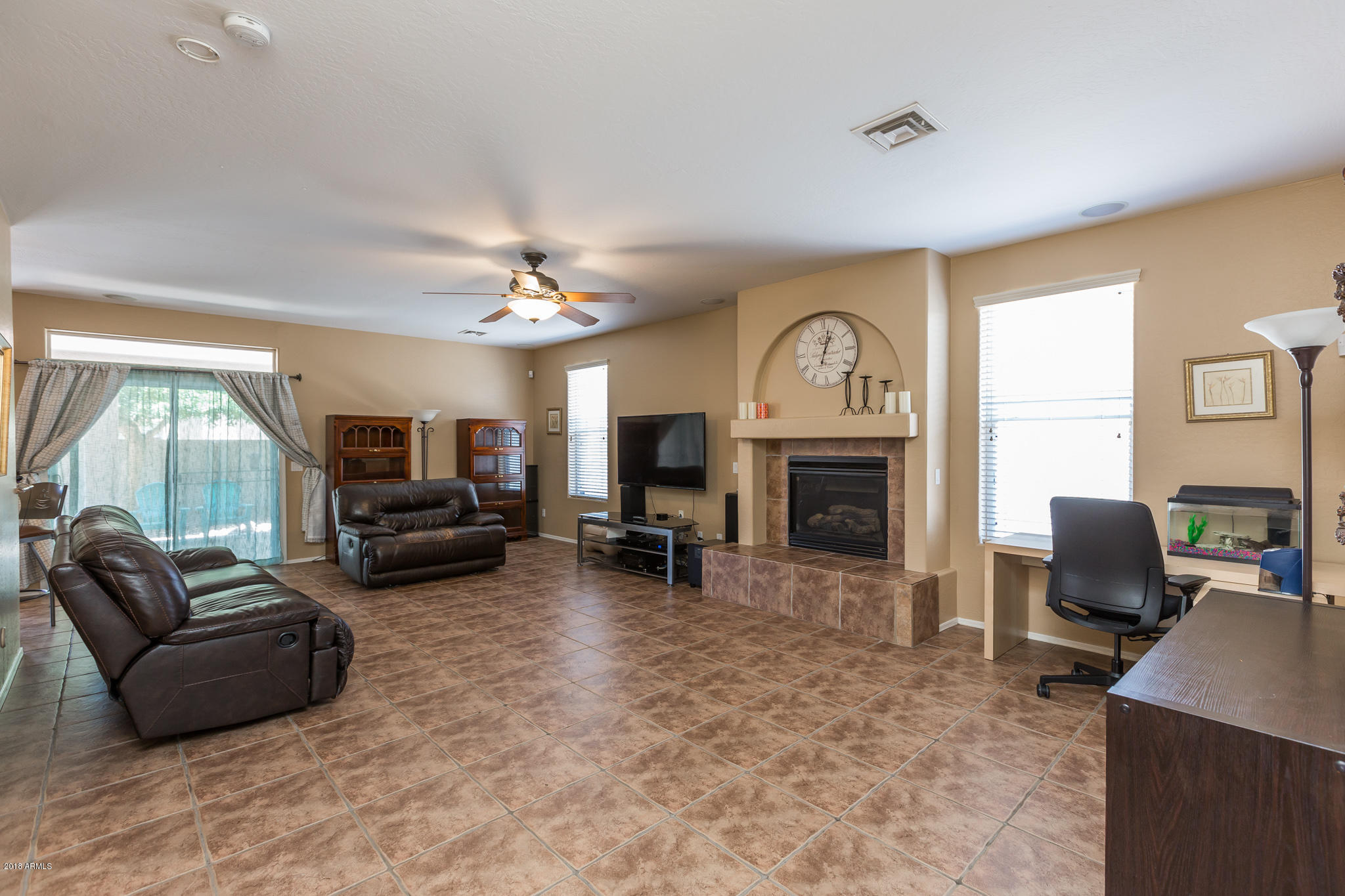 3744 East Del Rio Street Gilbert, AZ 85295 - Photo 12 of 32 a living room with furniture a fireplace and a flat screen tv