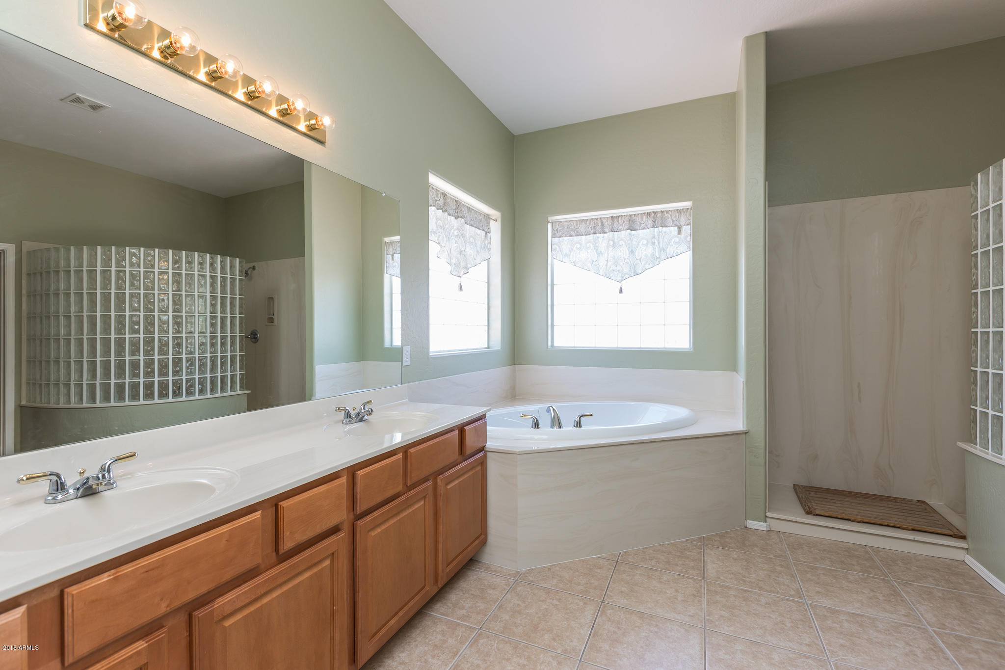 3744 East Del Rio Street Gilbert, AZ 85295 - Photo 16 of 32 a spacious bathroom with a double vanity sink a large mirror and bathtub