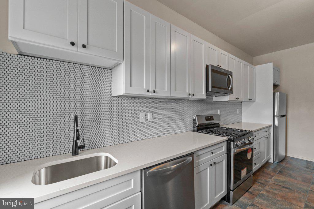 217 East Preston Street Baltimore, MD 21202 - Photo 11 of 60 a kitchen with stainless steel appliances granite countertop a sink stove and microwave