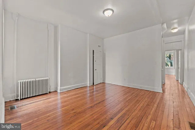 a view of empty room with wooden floor