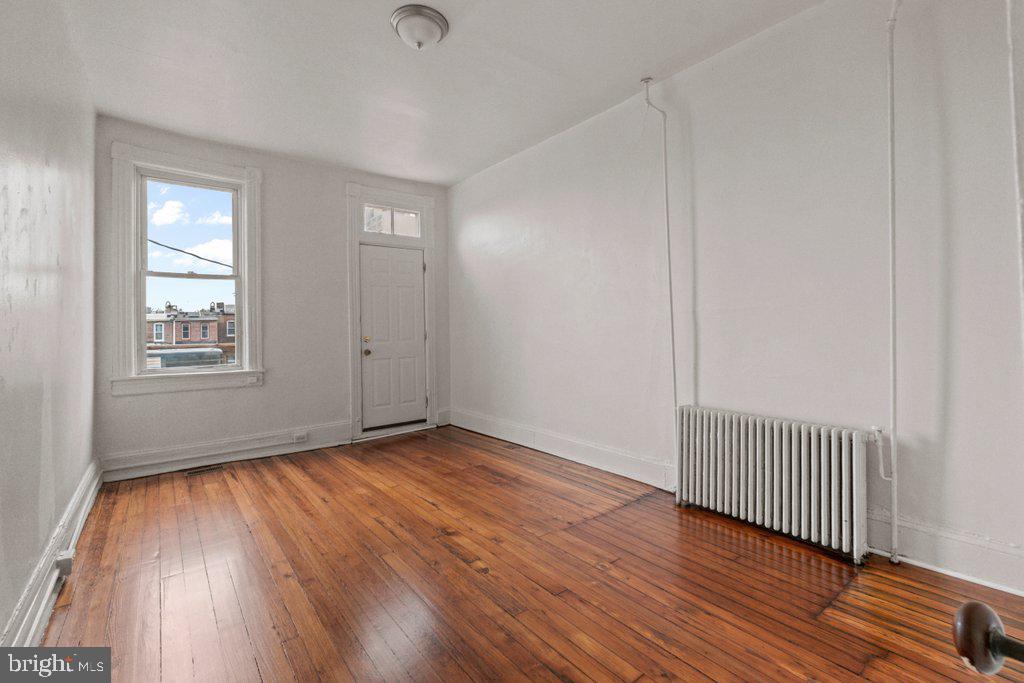 217 East Preston Street Baltimore, MD 21202 - Photo 18 of 60 an empty room with wooden floor and windows