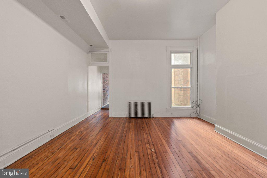 217 East Preston Street Baltimore, MD 21202 - Photo 6 of 60 an empty room with wooden floor and windows