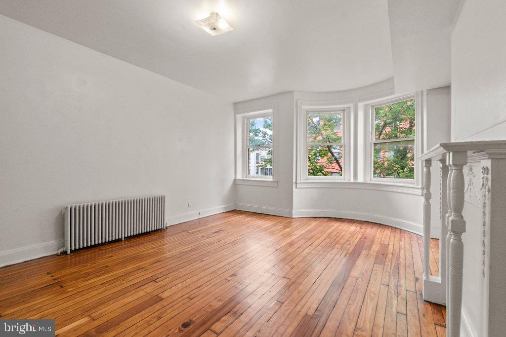 217 East Preston Street Baltimore, MD 21202 - Photo 9 of 60 a view of an empty room with wooden floor and a window