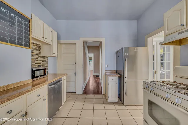 a kitchen with stainless steel appliances granite countertop a refrigerator and a stove