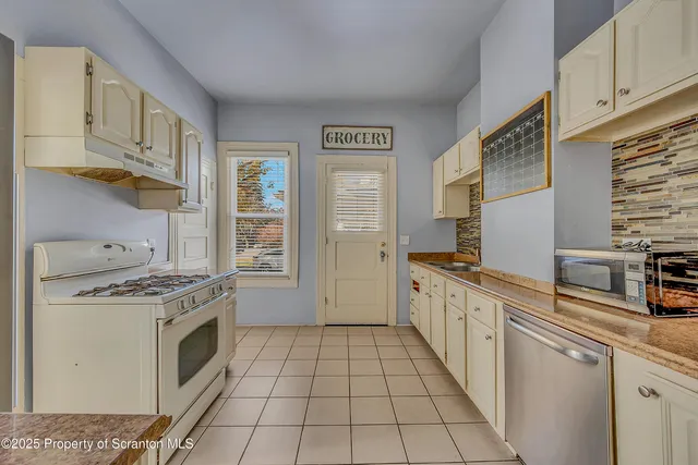 a kitchen with stainless steel appliances a stove a sink and a refrigerator