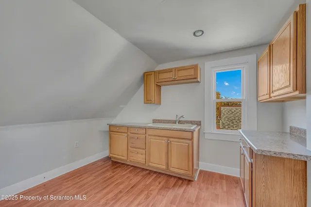 a kitchen with a sink cabinets and wooden floor