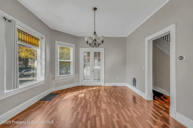 a view of a room with wooden floor windows and a chandelier