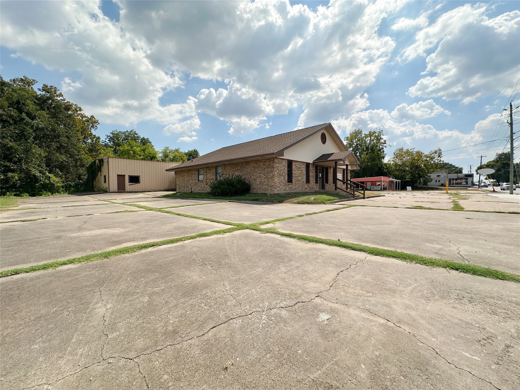702 North Richmond Road Wharton, TX 77488 - Photo 6 of 24 a backyard of a house with table and chairs under an umbrella