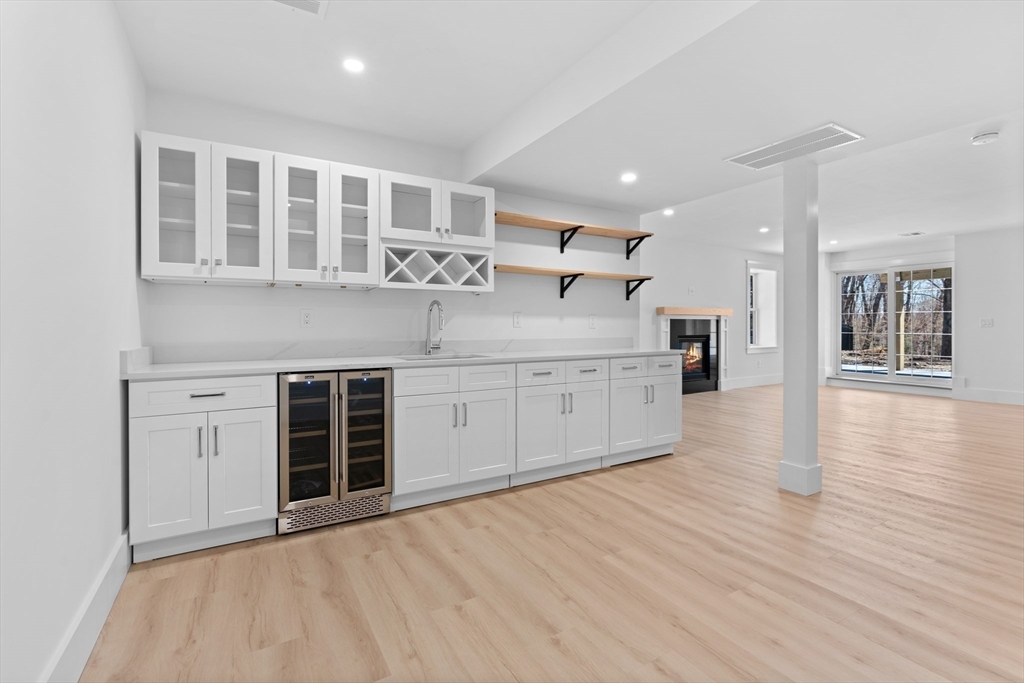 6 Sanders Lane Bolton, MA 01740 - Photo 33 of 36 a large white kitchen with kitchen island a sink wooden floor and stainless steel appliances