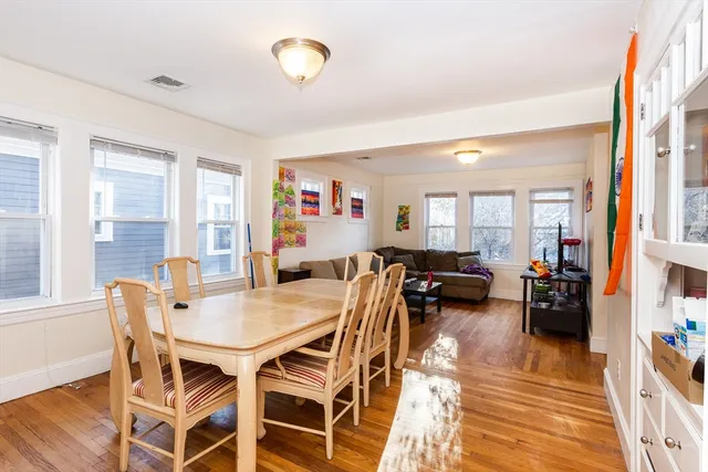 a view of a dining room and livingroom with furniture wooden floor and a rug