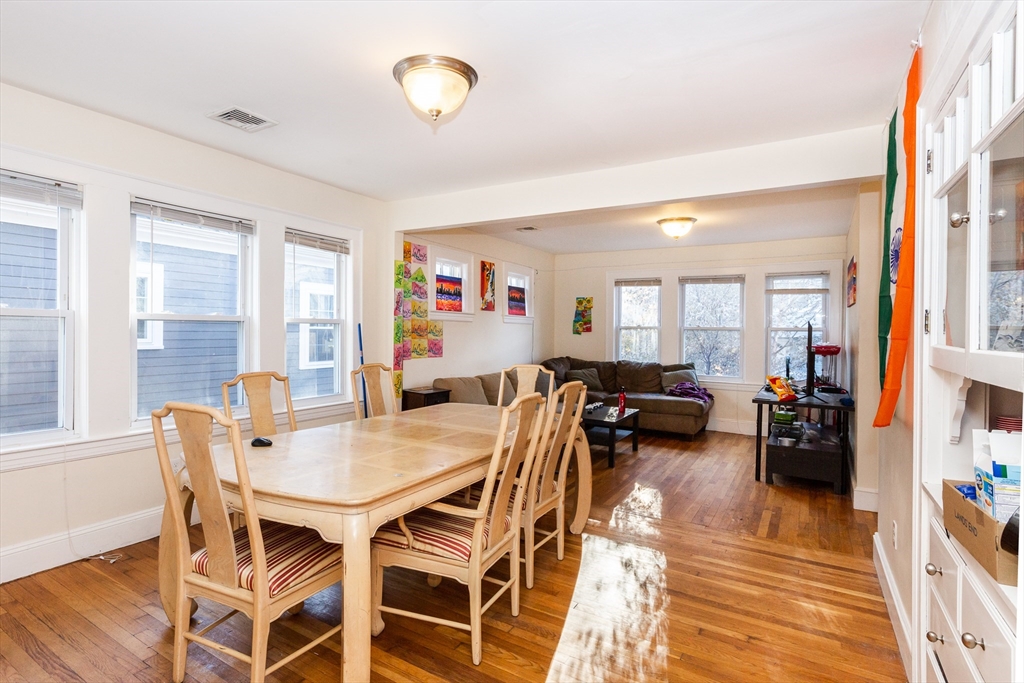 a view of a dining room and livingroom with furniture wooden floor and a rug