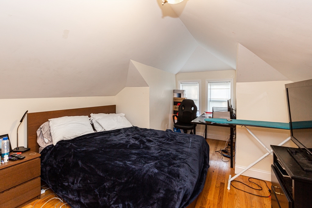 186 Calumet Street, Unit 186 Boston, MA 02120 - Photo 10 of 13 a large bed sitting in a room next to a lamp with a rug