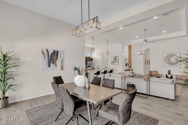 a living room with furniture kitchen view and a chandelier