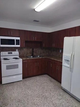 a kitchen with a stove a refrigerator and a sink