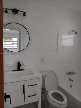 a bathroom with a toilet a sink and a mirror