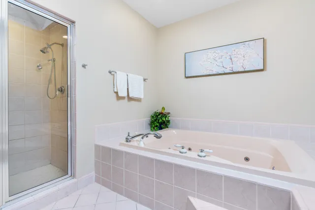 a bathroom with a granite countertop double vanity sink a mirror and a bathtub