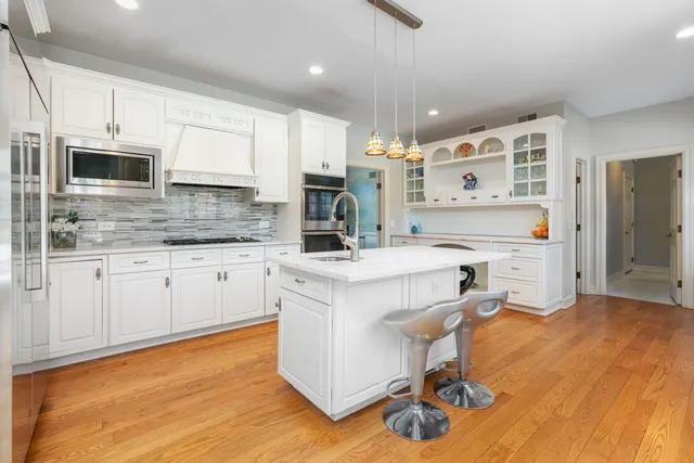 a kitchen with kitchen island granite countertop a sink cabinets and stainless steel appliances