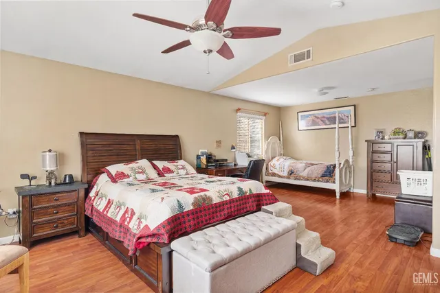 a bedroom with bed and wooden floor