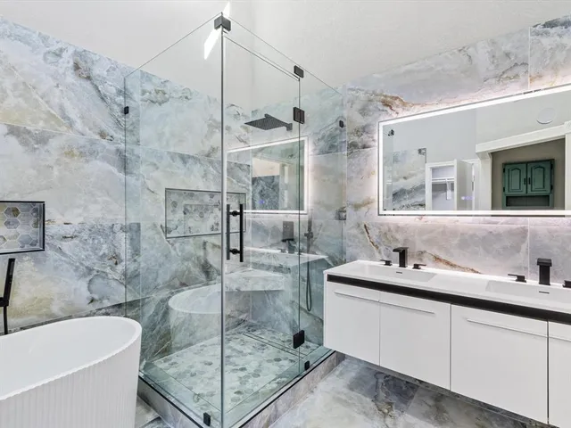 a bathroom with a tub sink mirror and vanity