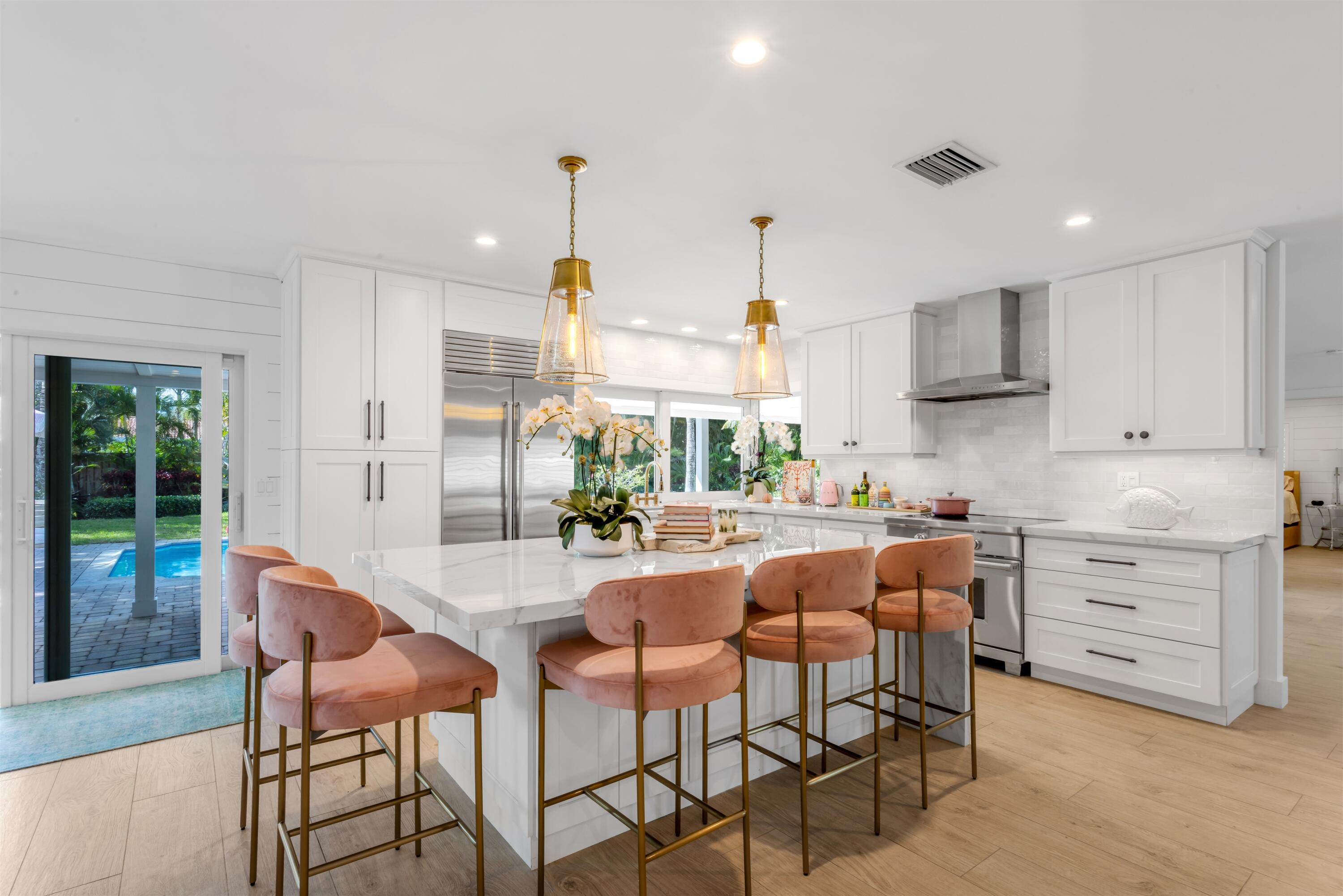 2720 Cardinal Circle Gulf Stream, FL 33483 - Photo 11 of 28 a kitchen with stainless steel appliances kitchen island granite countertop a table chairs and a refrigerator